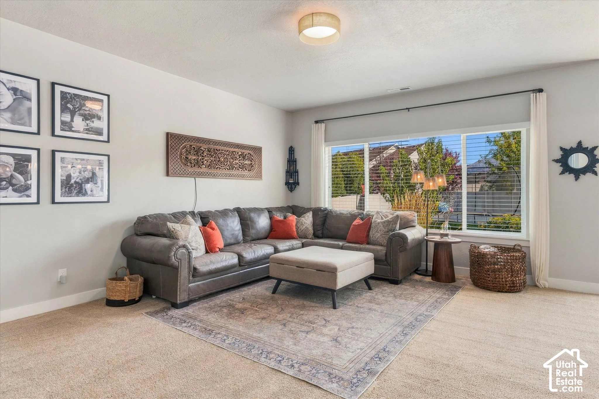 Recessed ceiling lighting, large window with horizontal blinds, neutral wall paint, and light-toned carpeting