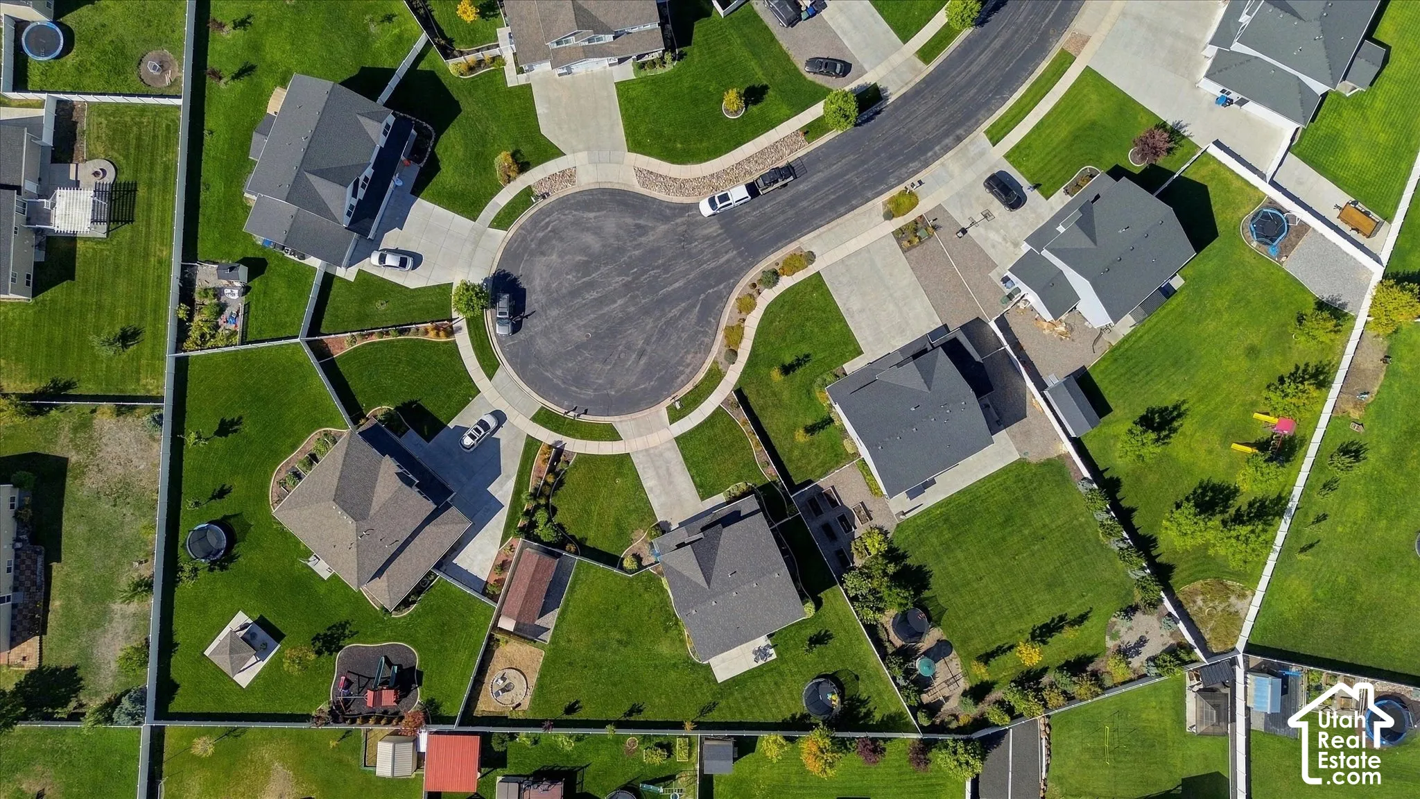 Cul-de-sac street with surrounding residences, featuring green lawns and fenced property lines
