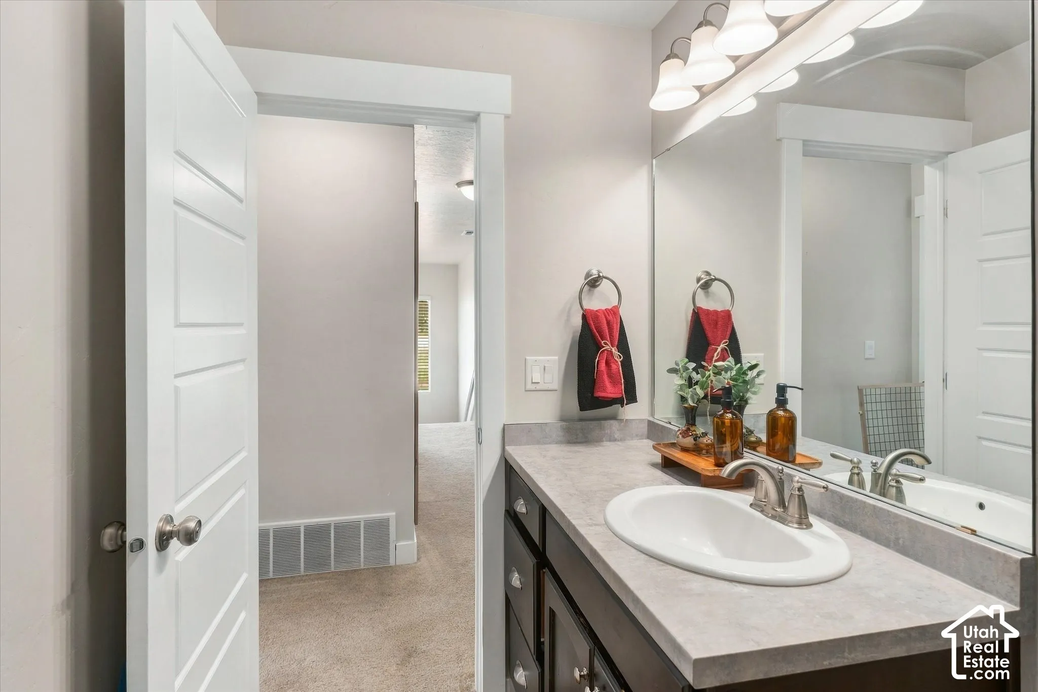 Bathroom vanity with a rectangular undermount sink, brushed nickel faucet, and a large wall-mounted mirror
