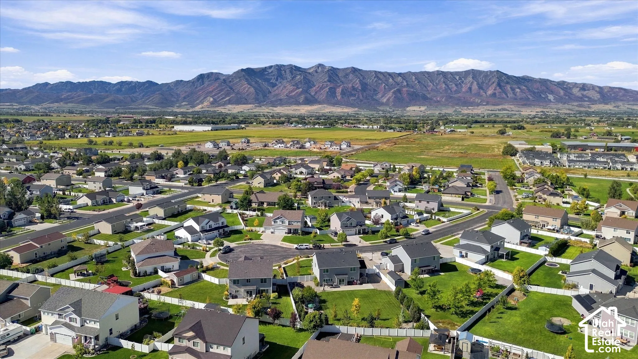 Mountain backdrop with residential properties and expansive green spaces