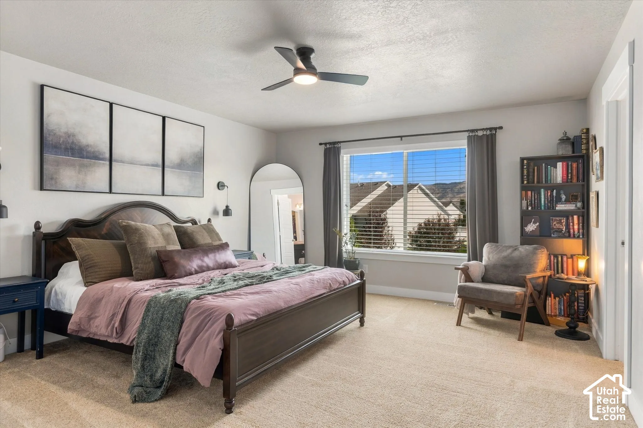 Recessed window with white trim, ceiling fan with integrated lighting, and neutral carpet flooring