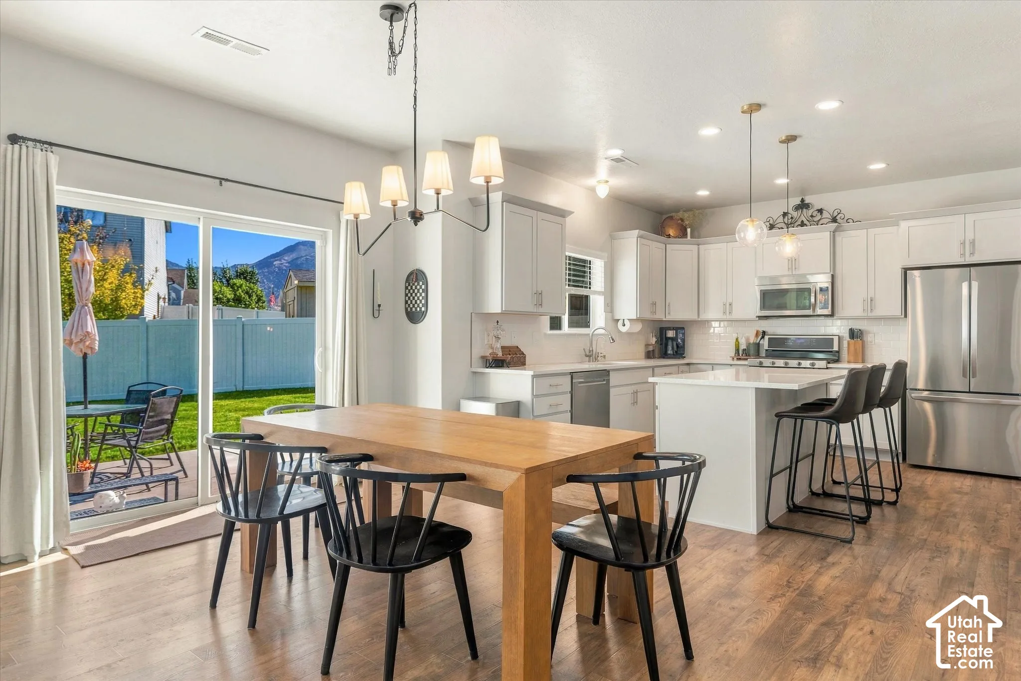 Modern kitchen with white cabinetry, stainless steel appliances, and a central island
