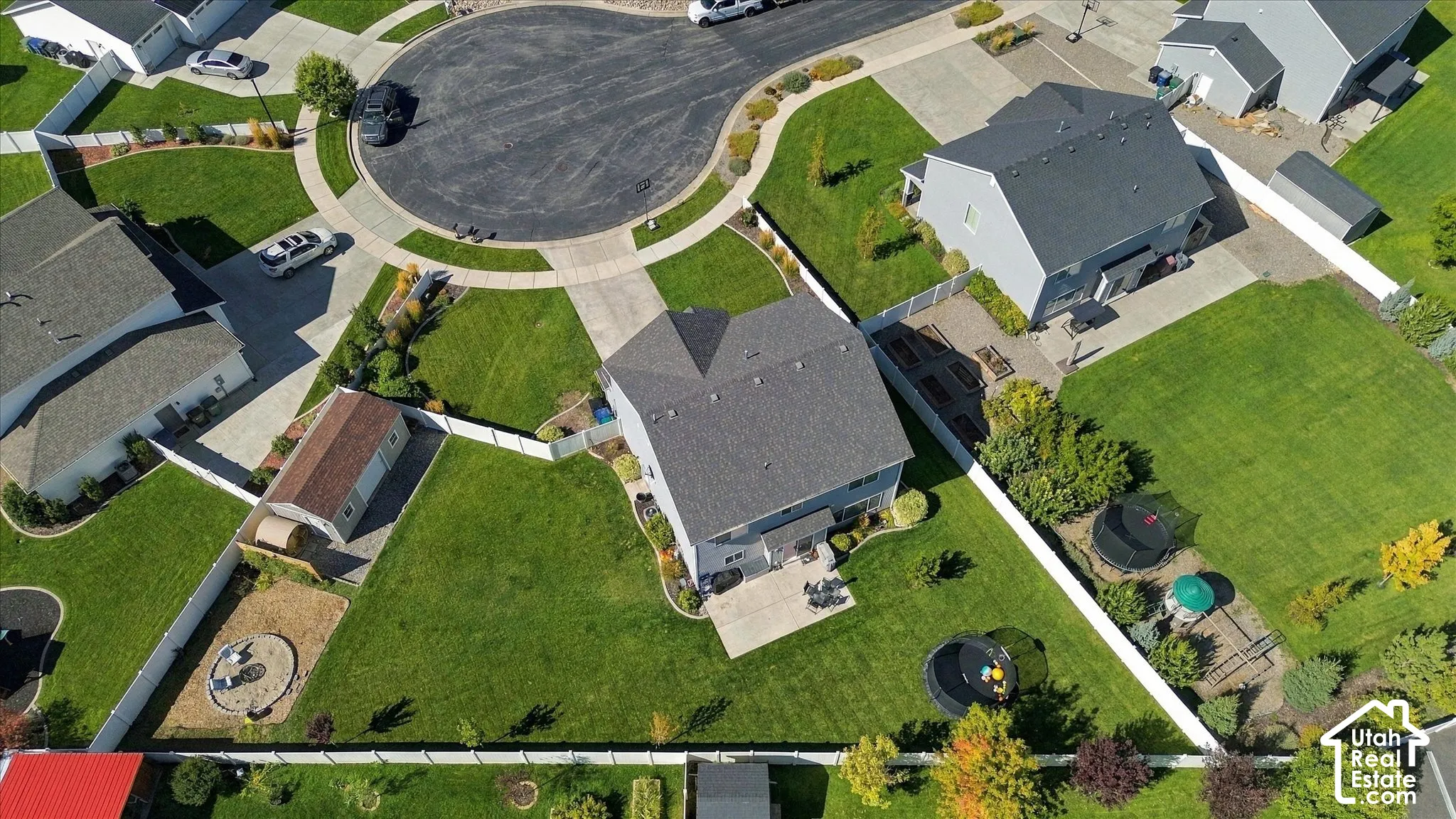 Single-family residence with a gray shingled roof and light gray siding, featuring a paved patio area