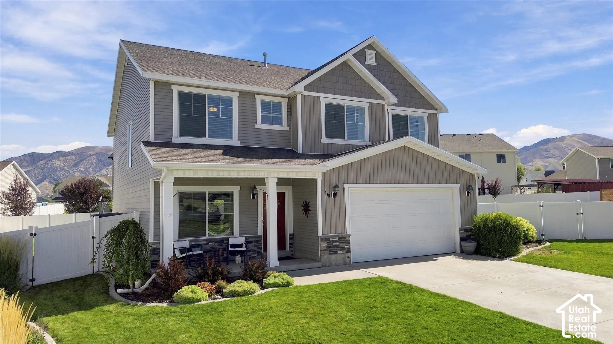 Two-story exterior with a covered porch, attached two-car garage, and a concrete driveway