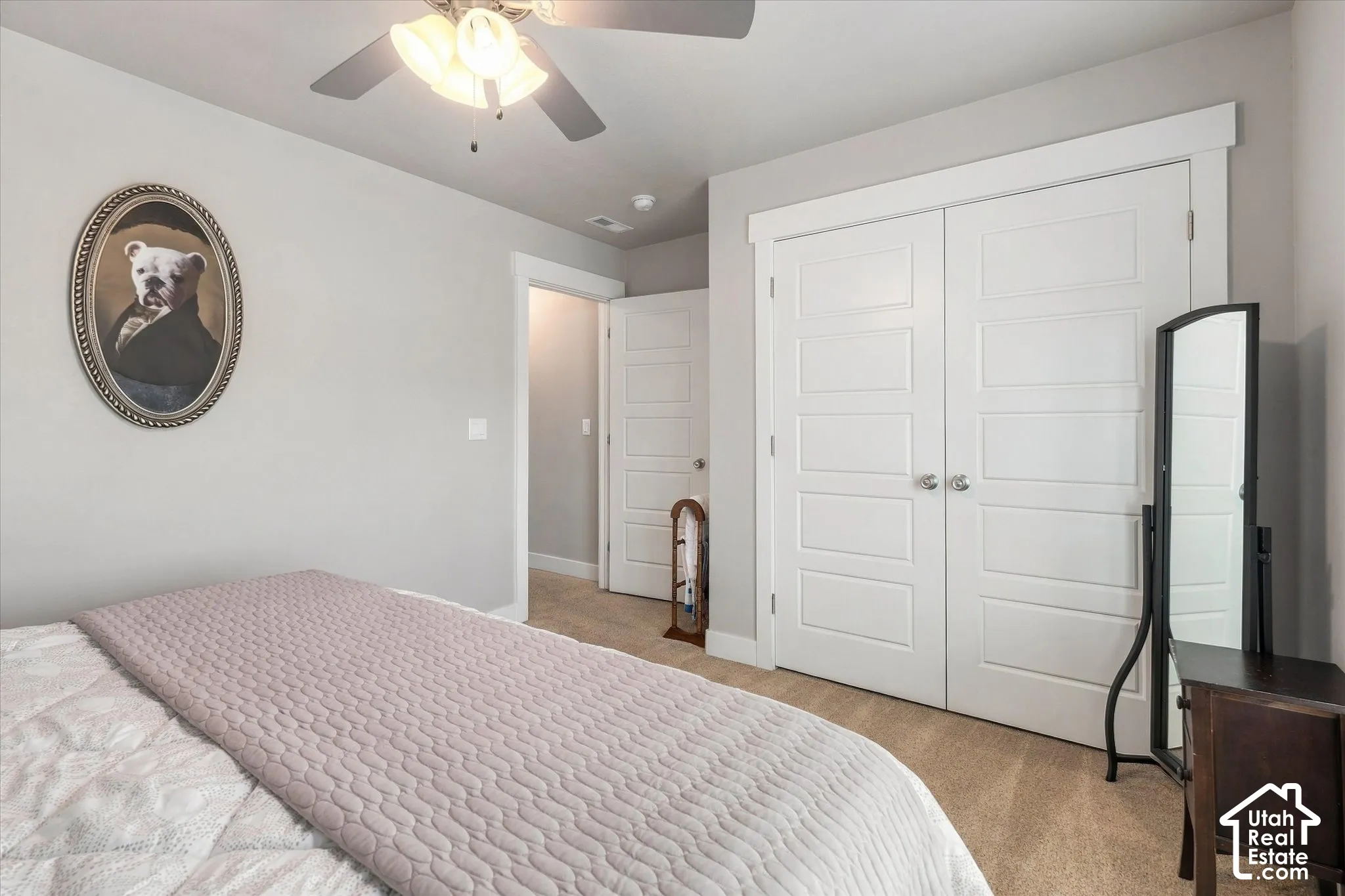 Carpeted flooring, ceiling fan with integrated lighting, white paneled doors, and light gray wall paint