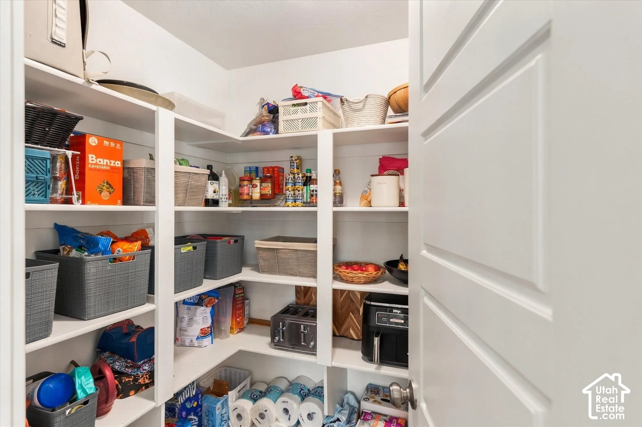Built-in shelving with multiple levels, white finish throughout, and a paneled interior door