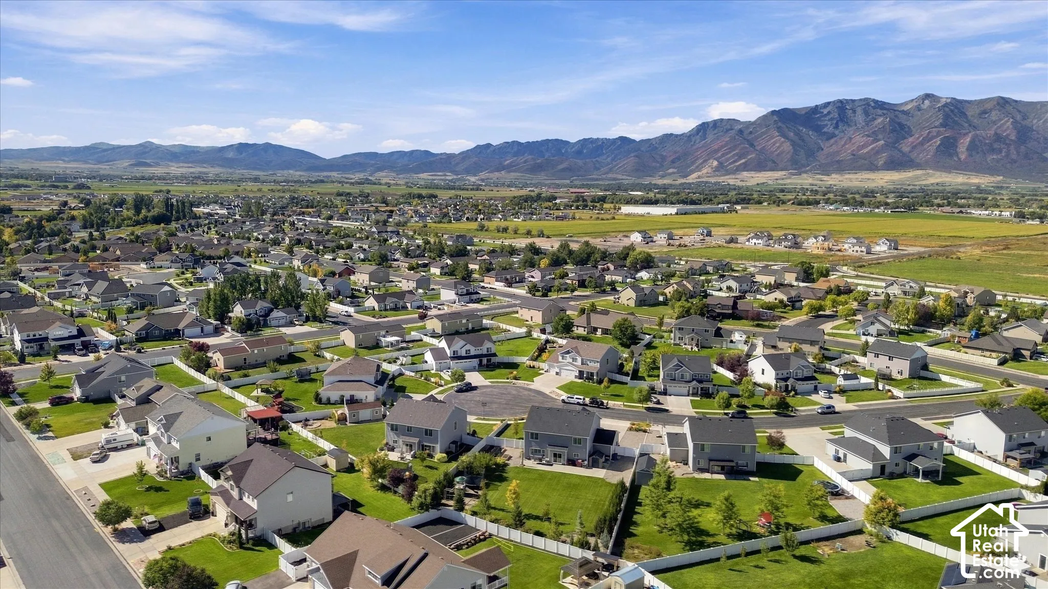Residential neighborhood with established homes, green landscaping, and distant mountain ranges