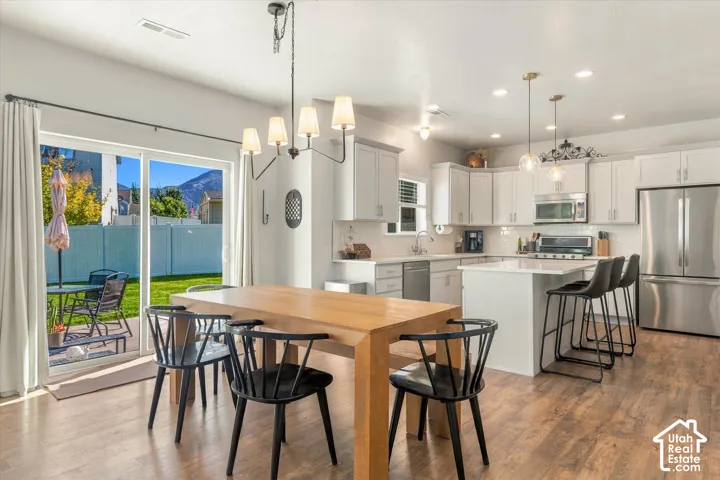 Modern kitchen with white cabinetry, stainless steel appliances, and a central island