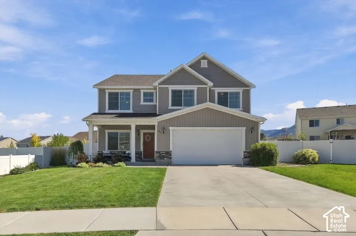 Two-story residence with a covered front porch, attached two-car garage, and a concrete driveway