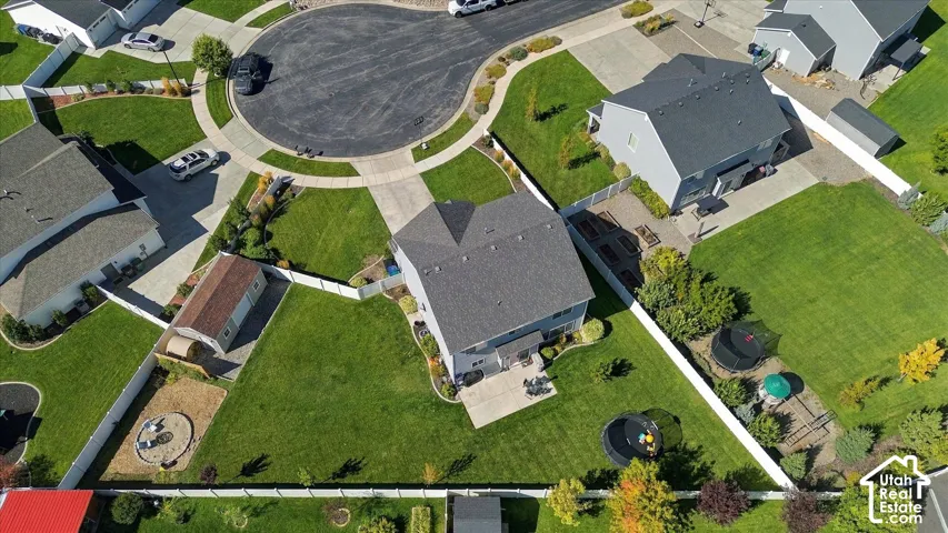Single-family residence with a gray shingled roof and light gray siding, featuring a paved patio area
