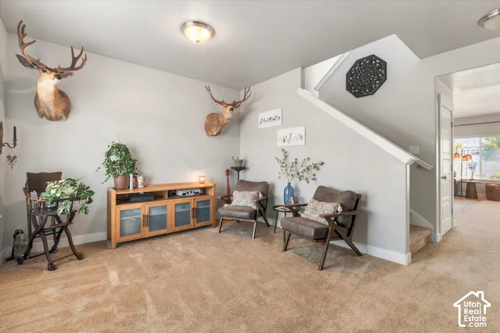 Carpeted flooring extending to a carpeted staircase, light-toned wall paint, and recessed ceiling lighting