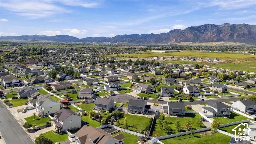 Residential neighborhood with established homes, green landscaping, and distant mountain ranges