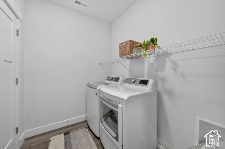 Dedicated laundry area featuring wood-finish flooring and a white wire shelf