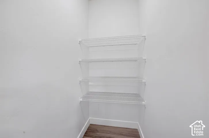 Built-in wire shelving with three tiers, white walls, and wood-finish flooring