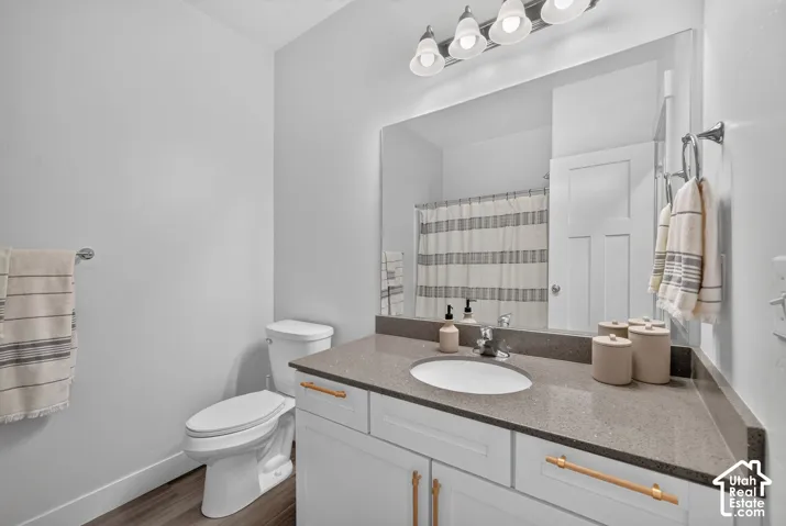 White vanity with gold-finish hardware, a gray countertop, and an integrated sink