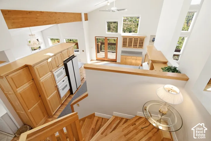 Vaulted ceilings, exposed wood beams, wood-finish flooring, built-in cabinetry, and multiple windows
