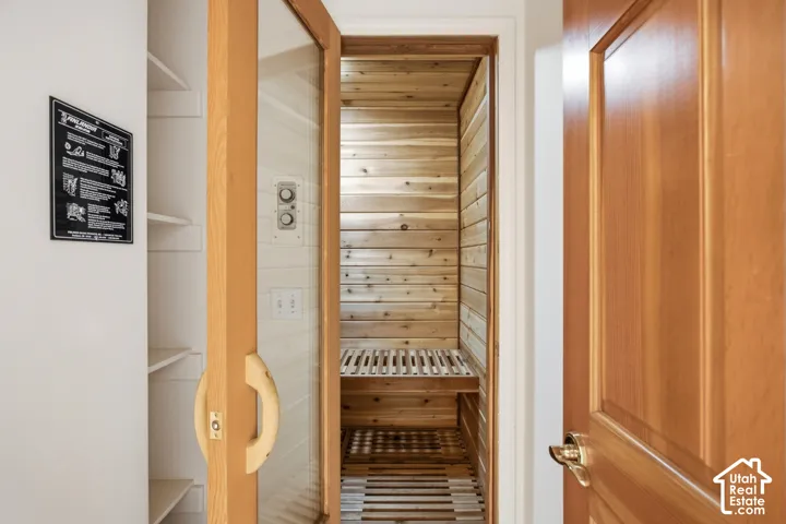 Built-in sauna with wood plank walls, wood slatted bench, and a glass-paneled door