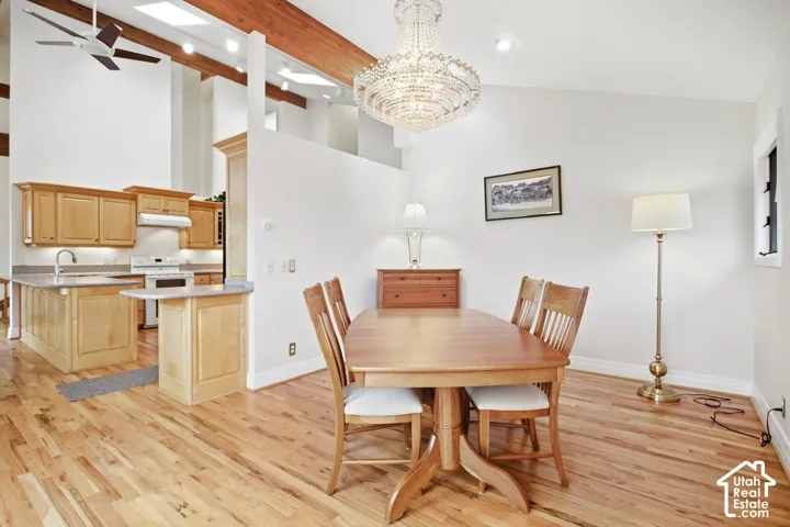 Hardwood flooring throughout, vaulted ceilings with exposed wood beams, and a ceiling fan
