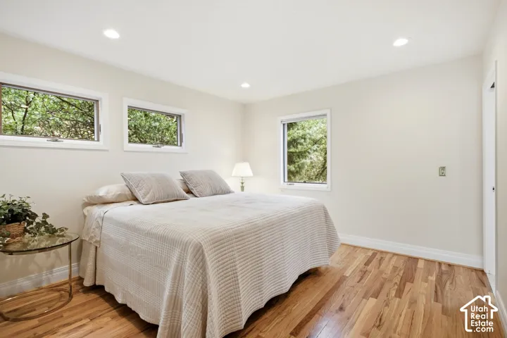 Hardwood flooring, recessed lighting, white trim, and multiple windows