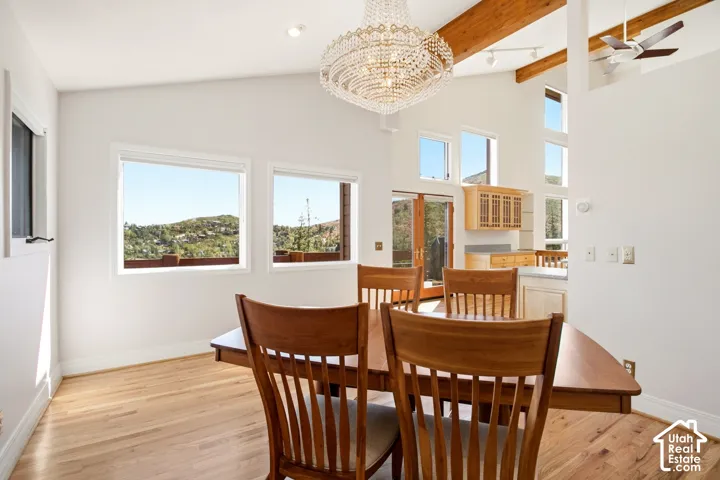 Hardwood flooring, exposed wood beams, vaulted ceilings, elegant crystal chandelier, and transom windows