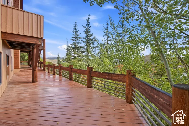 Expansive outdoor wood-finish deck with wood railing and metal balusters