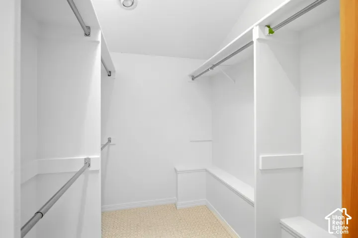 Walk-in closet featuring built-in shelving, hanging rods, recessed lighting, and light-toned flooring