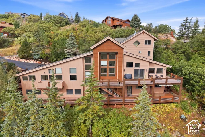 Multi-level exterior with extensive decking, a prominent central window feature, and diverse window configurations