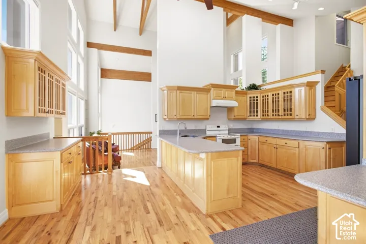 Kitchen featuring wood-finish cabinetry, light-toned countertops, and integrated appliances