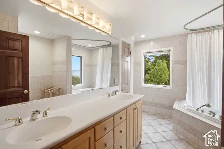 Dual vanity with integrated sinks, light wood-finish cabinetry, and polished chrome fixtures