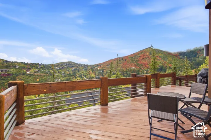 Expansive outdoor deck featuring wood-finish flooring and a robust wood railing with cable infill