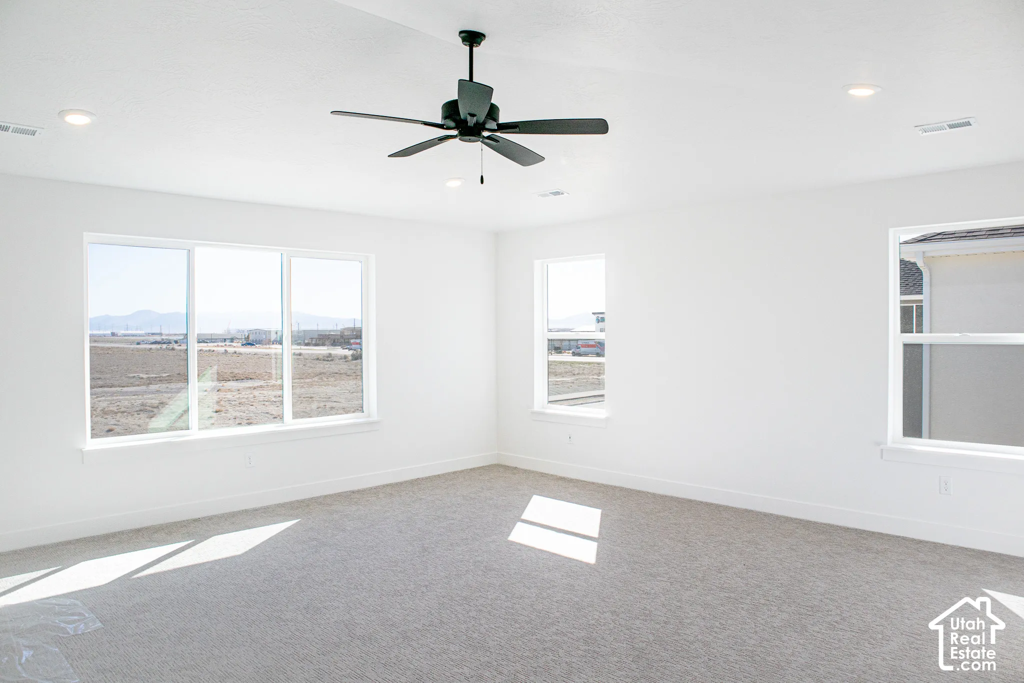 Spacious primary bedroom with great windows, vaulted ceiling and ceiling fan.