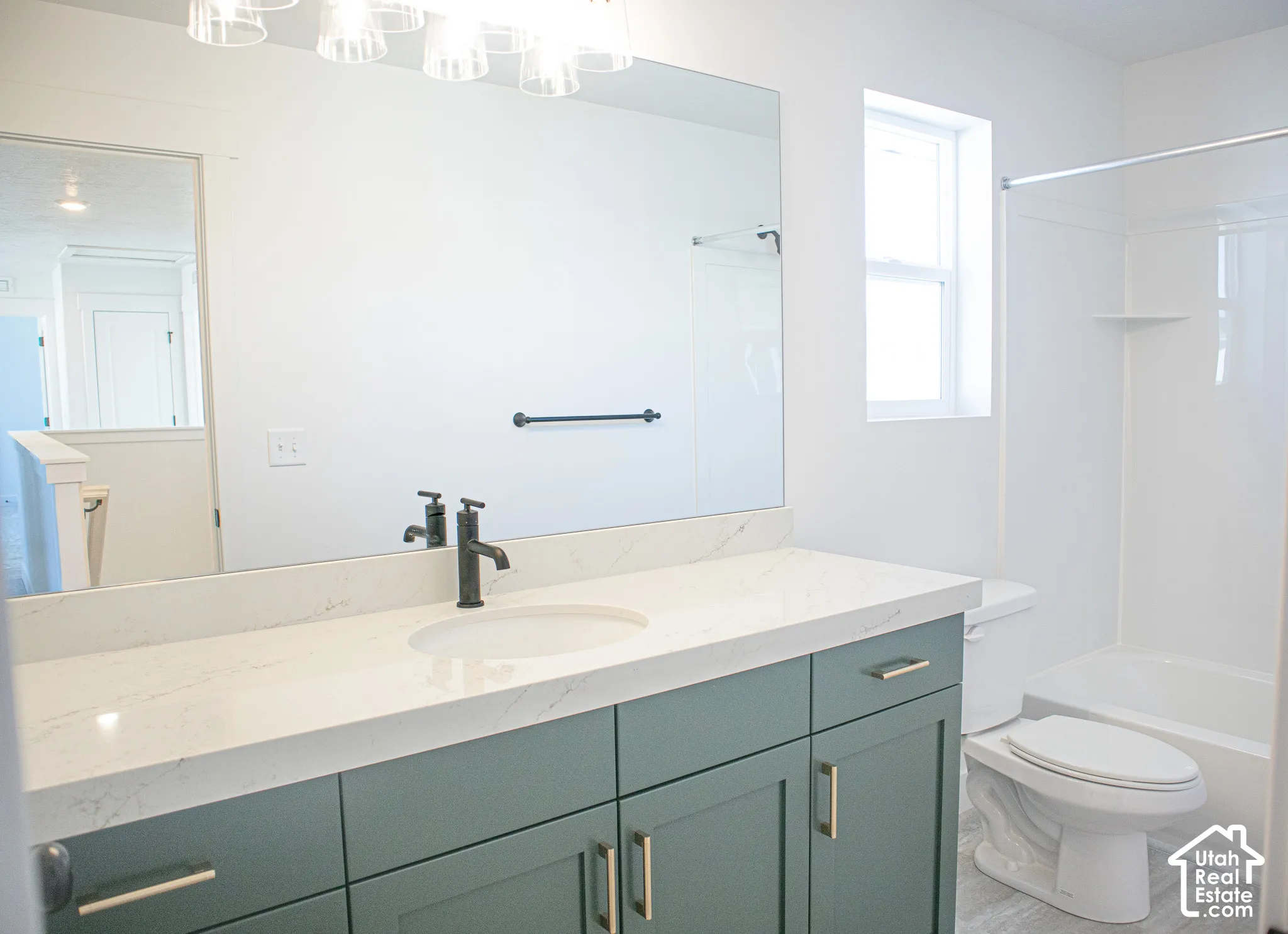 Full secondary bath with painted wood cabinets and quartz slab countertops.