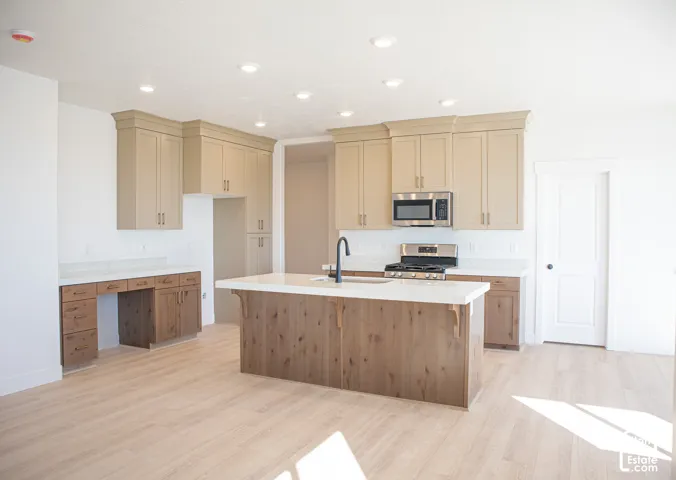 Terrific kitchen with ceiling-height, painted wood uppers; stained wood lower cabinets and island, quartz slab countertops, built-in desk, gas range, dishwasher, microwave and disposal adjacent to large dining area.