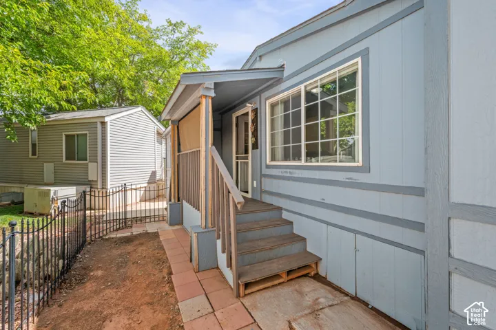 Covered porch entry featuring wood plank stairs and a protective railing