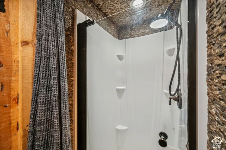 Shower enclosure featuring a black frame, matte black fixtures, and built-in shelving