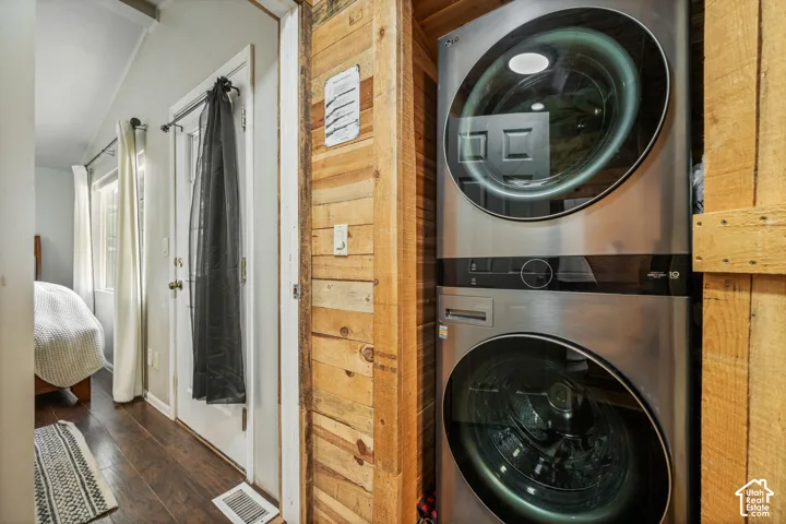 Stacked washer and dryer unit, wood-finish flooring, and natural wood paneling