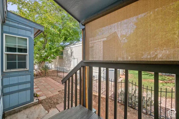 Outdoor patio featuring paver stones, a privacy screen, and an adjacent building with horizontal siding