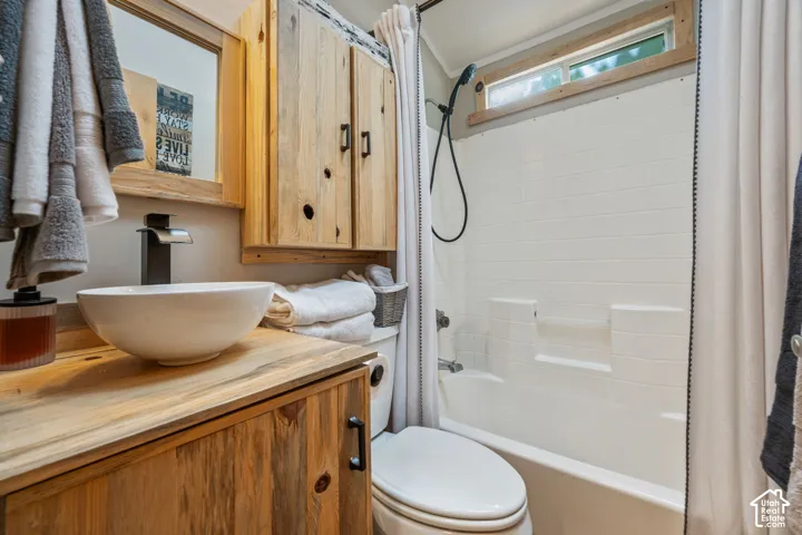 Wood-finish vanity with a vessel sink and black faucet