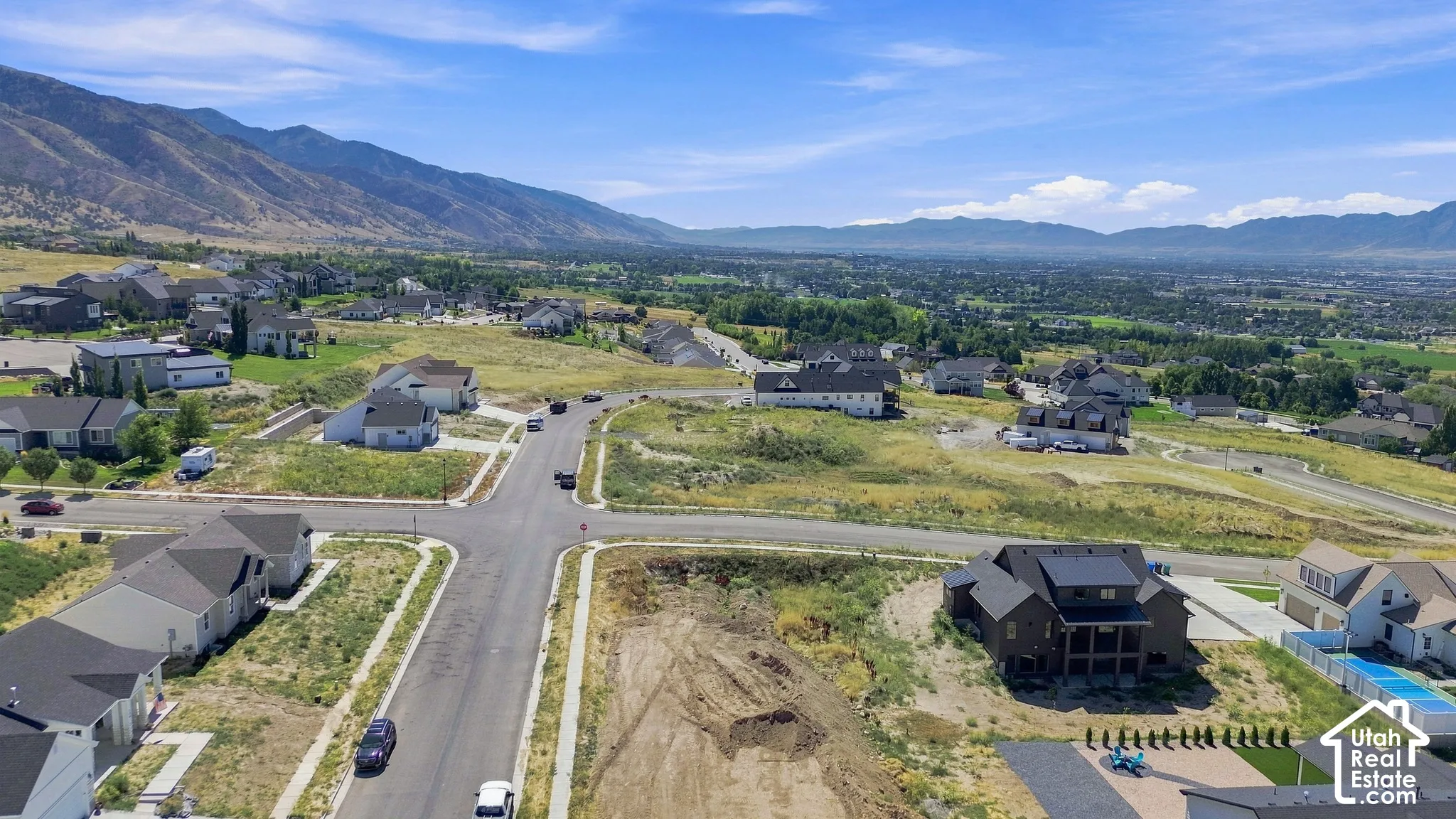 Mountain backdrop, residential street, structured development, established neighborhood, clear sky