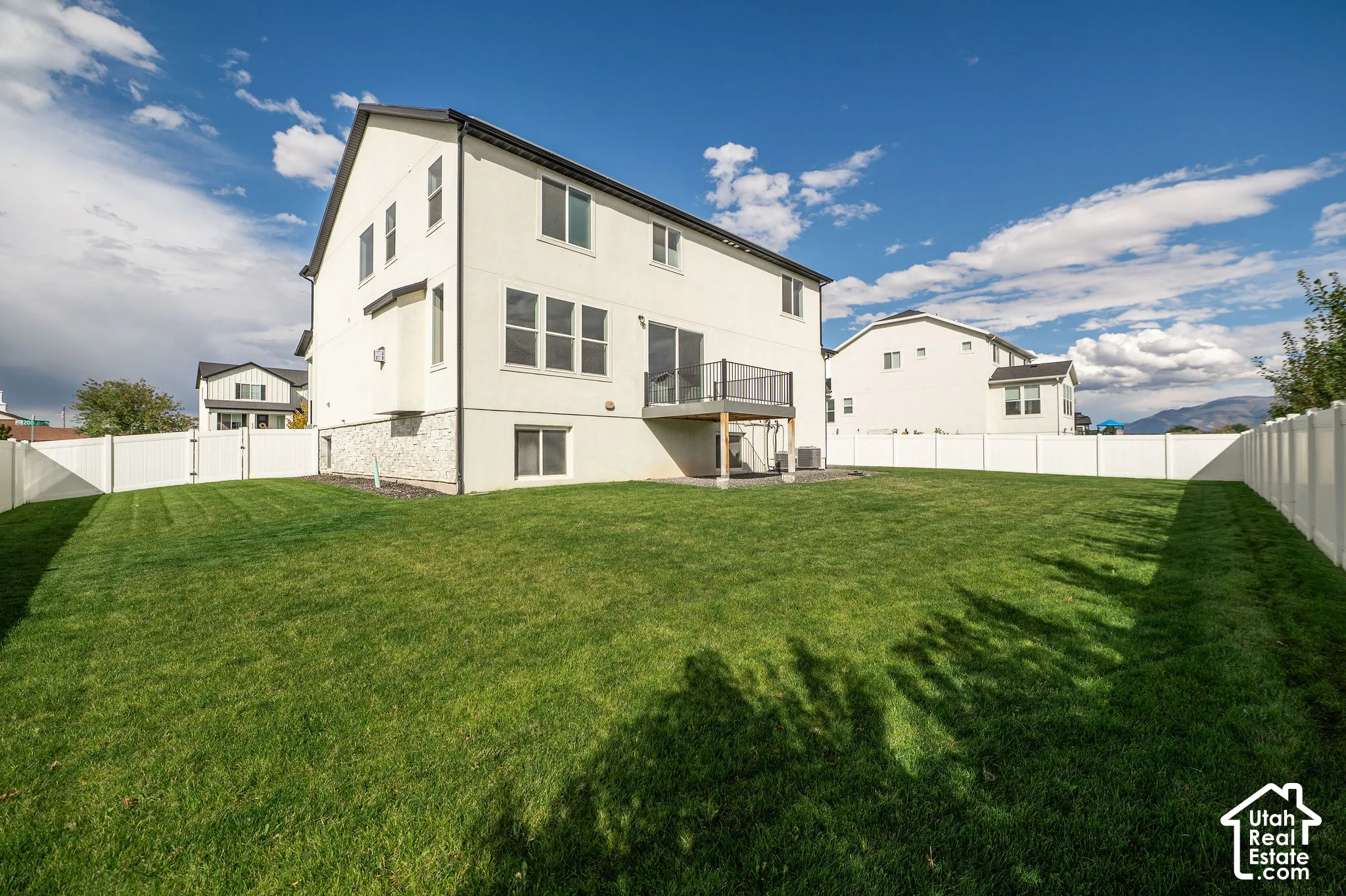 Expansive green lawn with a full privacy fence