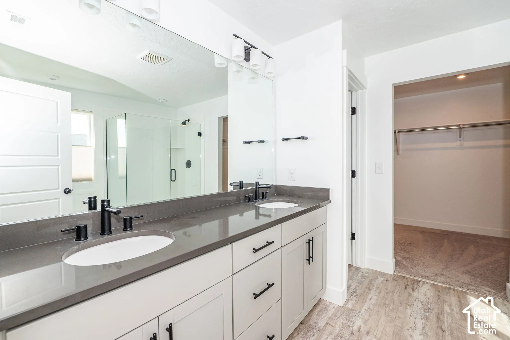 Dual vanity with a dark countertop and matte black fixtures in master