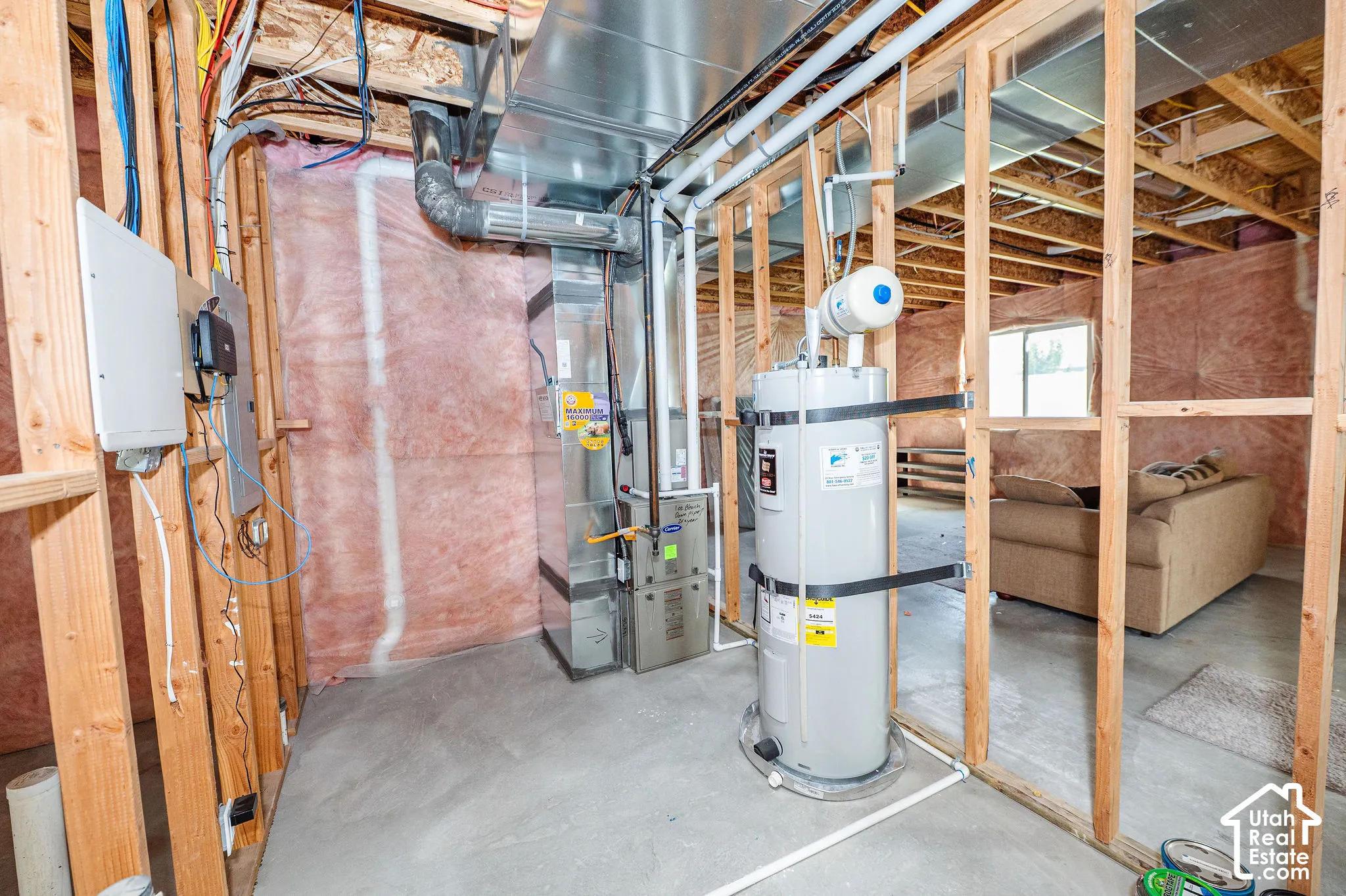 Unfinished basement area featuring a water heater, furnace,