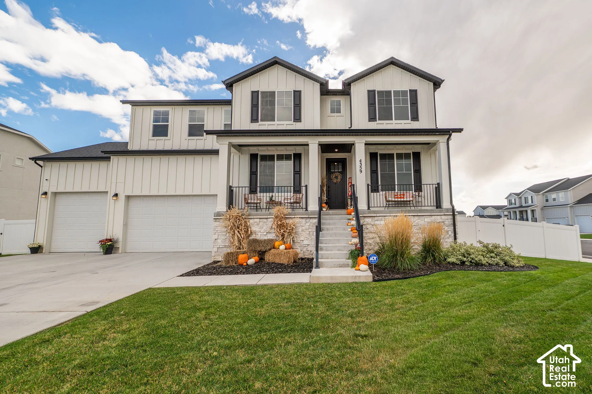 Two-story exterior with board and batten siding, stone facade accents, a covered front porch, and an attached two-car garage