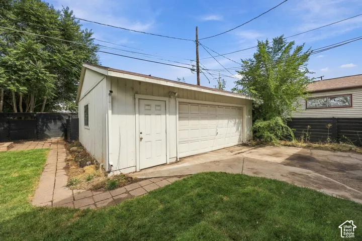 Detached structure with a panel garage door, a side entry door, and a single window