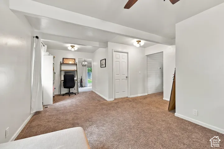 Carpeted interior with white walls, ceiling fan, and flush-mount lighting fixtures