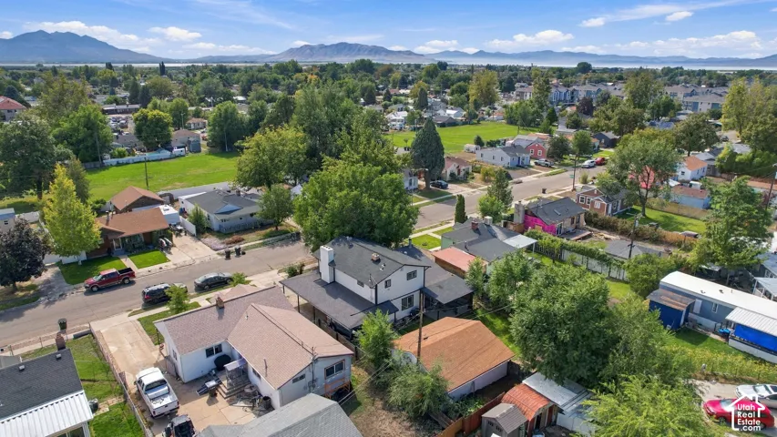 Aerial perspective showcasing neighborhood setting with mature trees and mountain backdrop