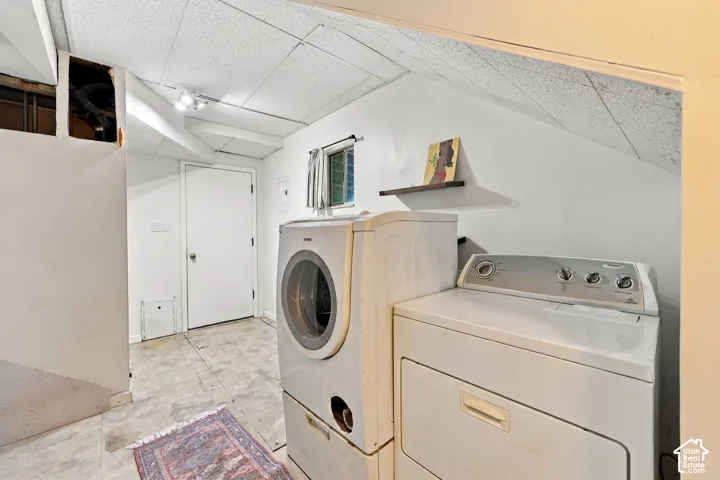 Laundry area with tile flooring and track lighting