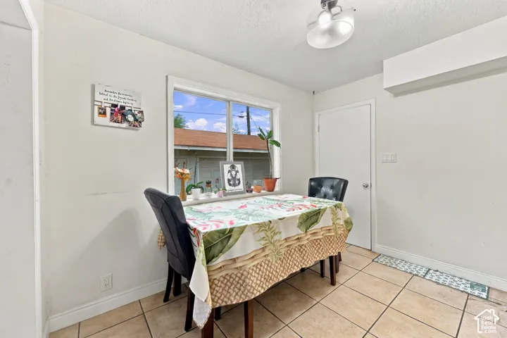 Tiled flooring, white painted walls, natural light from a window, and overhead lighting