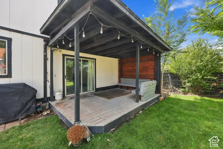 Covered patio featuring a wood-finish accent wall and a built-in bench
