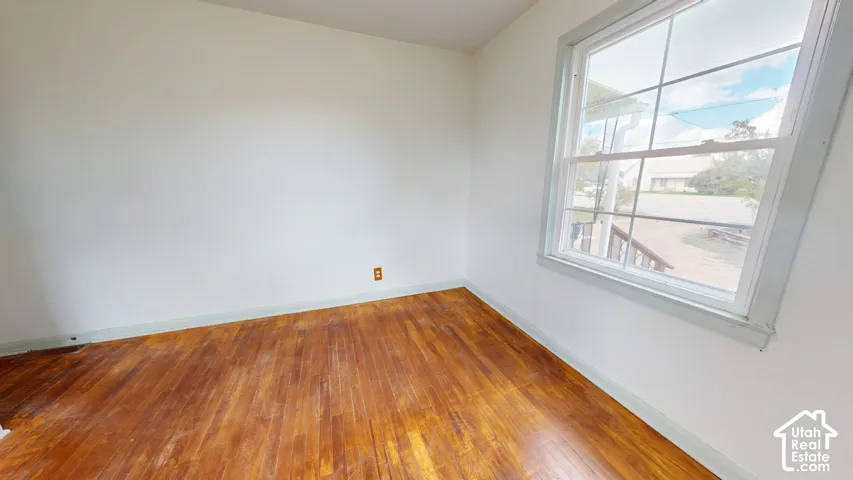 Hardwood flooring, painted walls, and a multi-pane window
